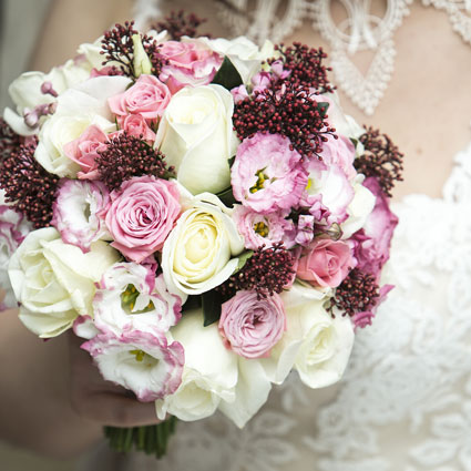 Flowers. White and soft pink roses with matching decorative floral accents in a classic bridal bouquet.

A wedding