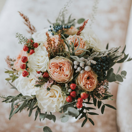 Flower delivery Riga. Bridal bouquet in pastel colors with peony-style roses and accents of decorative berries and fine