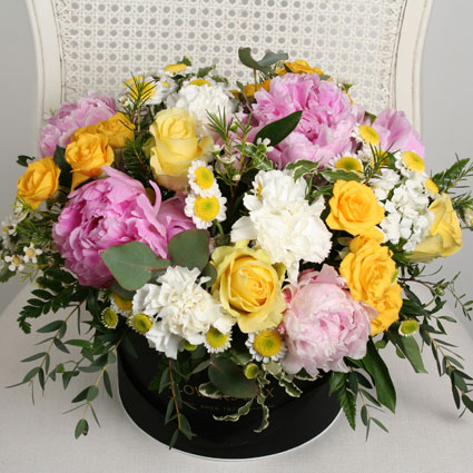 Flowers. Flower box of pink peonies, yellow roses, white carnations and decorative foliage.